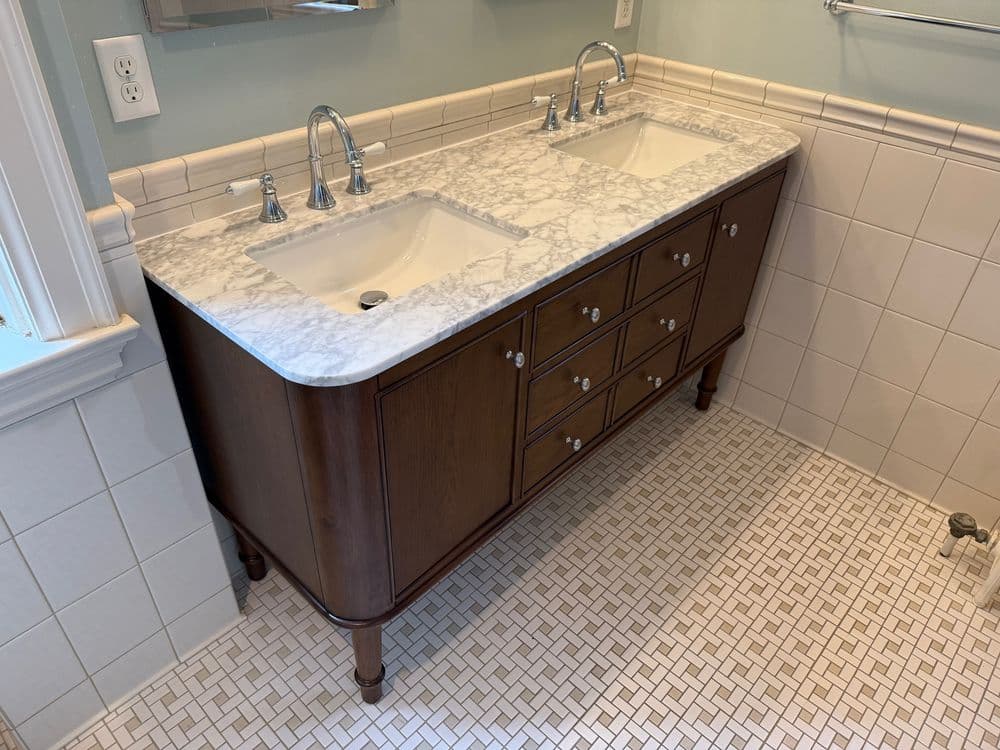 Double sink bathroom vanity with marble countertop and wooden cabinetry. Elegant and functional design.